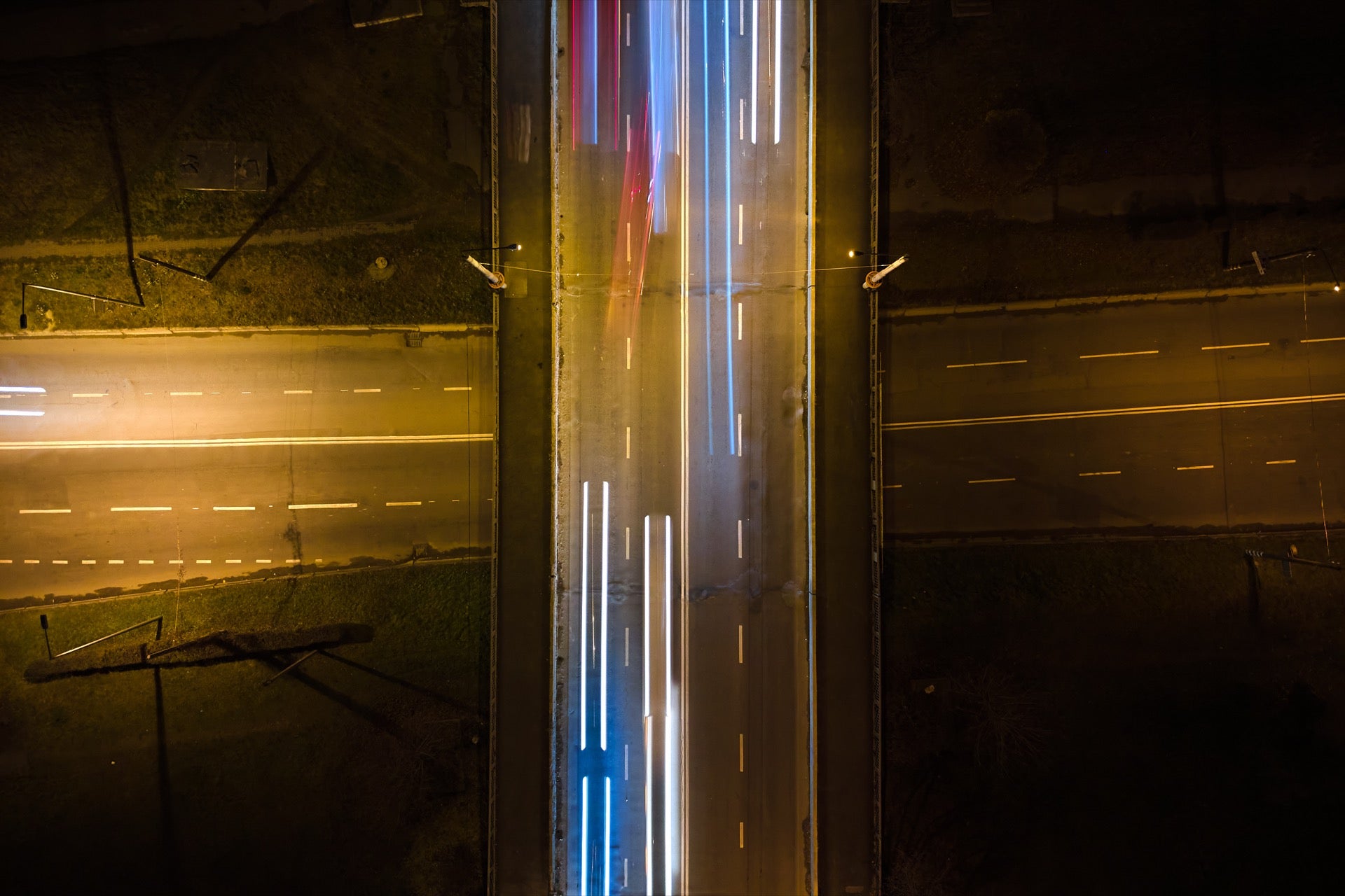 Aerial view of road intersection with fast-moving traffic at night